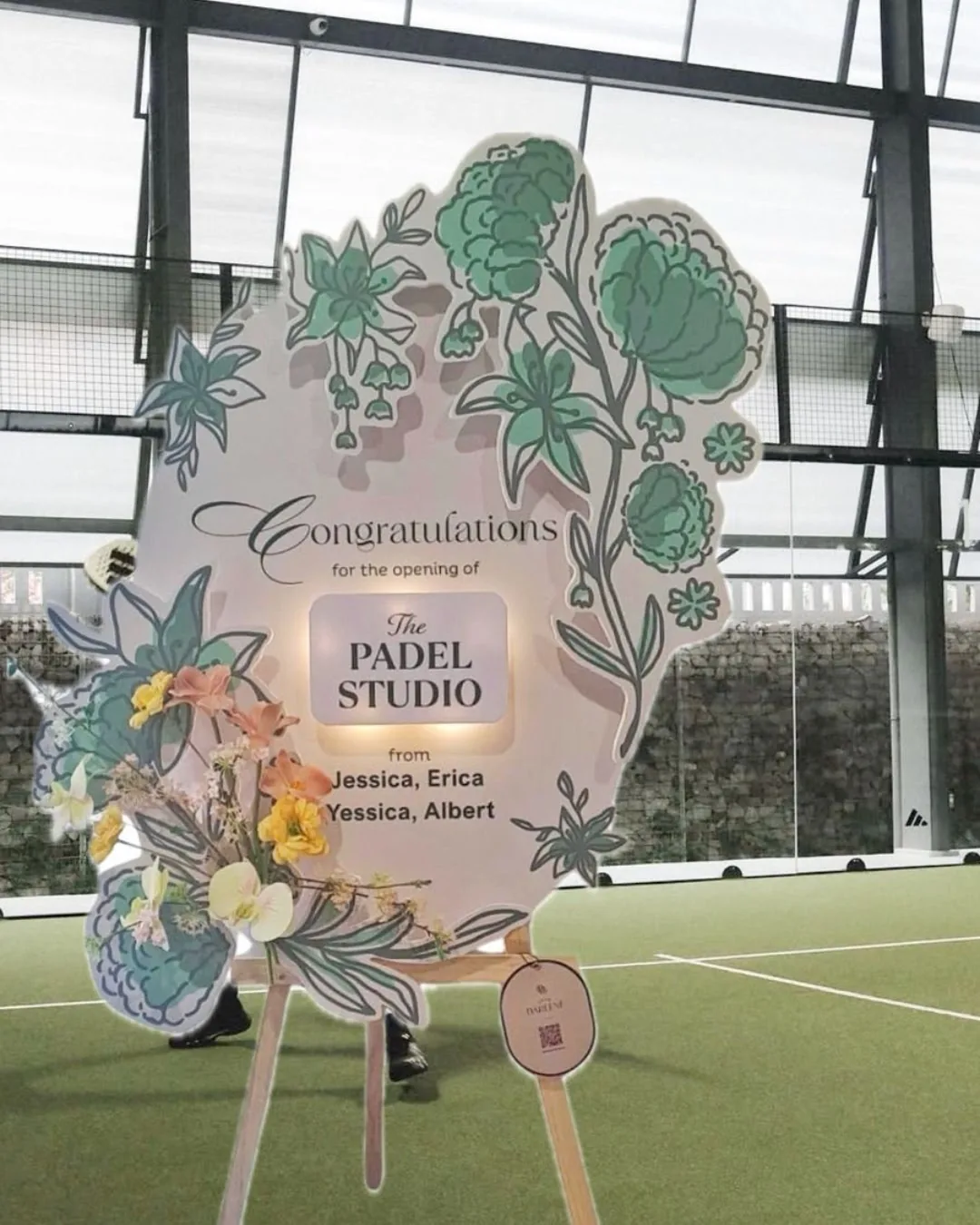 Papan bunga Dear Darlene dengan potongan tepi rapi berdiri di lapangan padel